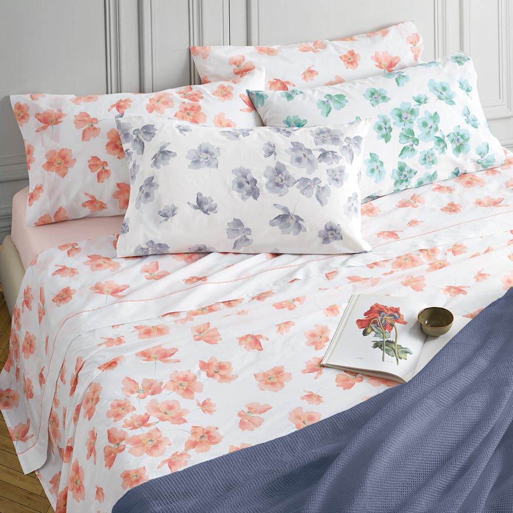 Lenzuolo Copriletto matrimoniale Somma Florence, in freschissimo percalle di puro cotone. Il completo lenzuola Florence è caratterizzato da una delicata fantasia floreale su fondo bianco. Nella foto sono presenti le tre varianti di colore, rispettivamente con fiori corallo, bluette e verde acqua. La stampa è presente sulle federe e sul lenzuolo superiore, compresa la balza. Il lenzuolo con angoli è in falso unito color corallo, carta da zucchero o verde acqua.