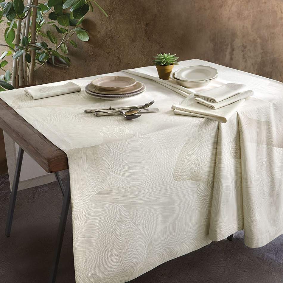 Servizio tavola Zante della linea Gabel Vallesusa, in raso di puro cotone. Raffinatissima tovaglia con fantasia jacquard dalle linee morbide e sinuose, su fondo beige chiaro. Disponibile nella misura rettangolare per 12 persone con 12 tovaglioli (160x320 cm) e nella misura per 18 persone con 18 tovaglioli (180x360 cm).