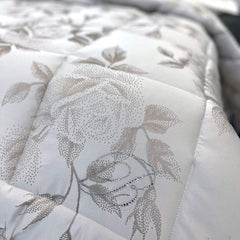 Trapunta Invernale matrimoniale Giorgia di Blumarine, in elegante raso jacquard. Romantica fantasia jacquard a tema floreale, colore ecrù, con logo Blumarine in preziosi cristalli Swarovski. dettaglio gantasia