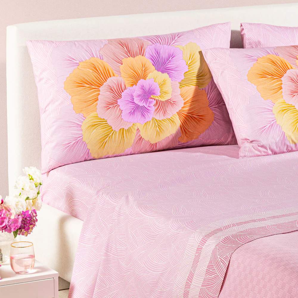 completo lenzuola madreperla caleffi. Federe con grande fiore rosa e arancio. Lenzuola con fantasia rosa a intrecci