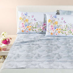 completo lenzuola caleffi yasmine. federe con fantasia a fiorellini arancio, rosa e blu. lenzuolo con foglie di ginkgo. variante grigio