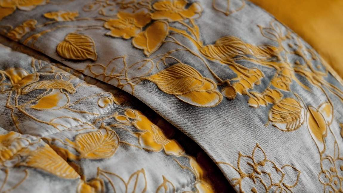 Completo lenzuola matrimoniale Fazzini Chinoiserie, in raso di puro cotone. La passione per le ceramiche orientali anima la collezione Chinoiserie. Il disegno floreale emerge sul fondo dall'effetto acquerellato e diventa tridimensionale grazie al profilo floccato e dorato. Il lato superiore delle federe e la balza del lenzuolo di sopra sono in raso di puro cotone tinto e sovrastampato con effetto tridimensionali laminati. Il resto del completo è in raso di cotone tinta unita oro ocra.