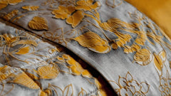 Completo lenzuola matrimoniale Fazzini Chinoiserie, in raso di puro cotone. La passione per le ceramiche orientali anima la collezione Chinoiserie. Il disegno floreale emerge sul fondo dall'effetto acquerellato e diventa tridimensionale grazie al profilo floccato e dorato. Il lato superiore delle federe e la balza del lenzuolo di sopra sono in raso di puro cotone tinto e sovrastampato con effetto tridimensionali laminati. Il resto del completo è in raso di cotone tinta unita oro ocra.