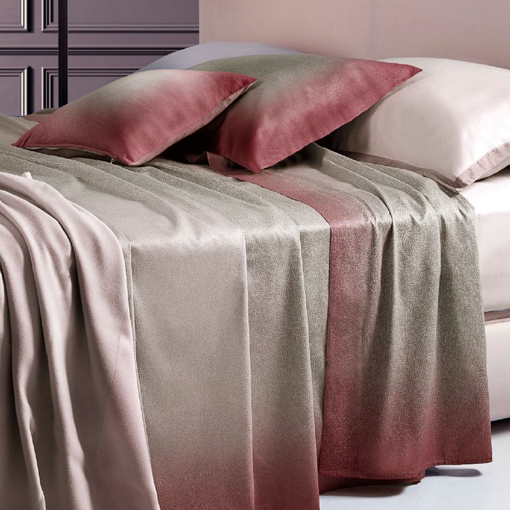 Completo lenzuola copriletto matrimoniale Borbonese Shade, in raso di puro cotone. Variante Bordeaux. Il lenzuolo copriletto Shade presenta una fantasia con la tipica stampa Borbonese a occhio di pernice. la tonalità è quella del tortora, che sfuma verso il bordeaux avvicinandosi al bordo del lenzuolo superiore e delle federe. Il lenzuolo con angoli è in raso di cotone tinta unita, color avorio/panna.
