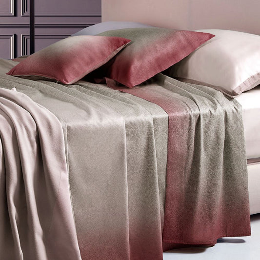 Completo lenzuola copriletto matrimoniale Borbonese Shade, in raso di puro cotone. Variante Bordeaux.  Il lenzuolo copriletto Shade presenta una fantasia con la tipica stampa Borbonese a occhio di pernice. la tonalità è quella del tortora, che sfuma verso il bordeaux avvicinandosi al bordo del lenzuolo superiore e delle federe. Il lenzuolo con angoli è in raso di cotone tinta unita, color avorio/panna.