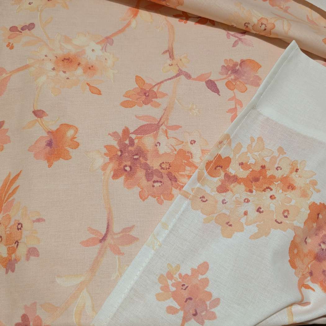Lenzuolo copriletto Graciosa Gabel. Fantasia con fiori arancio su fondo rosa pesca e bianco.