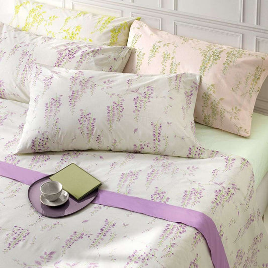 Lenzuolo Copriletto matrimoniale Sophie, in freschissimo percalle di puro cotone. Realizzato in Italia da Somma.Il completo lenzuola Sophie è caratterizzato da una delicata fantasia floreale. Nella foto sono presenti le tre varianti di colore: la prima con fiori glicine, la seconda con fiori verdi, la terza con fiori gialli. La stampa è presente sulle federe e sul lenzuolo superiore, compresa la balza. Il lenzuolo con angoli è in falso unito color verde chiaro o arancio chiaro