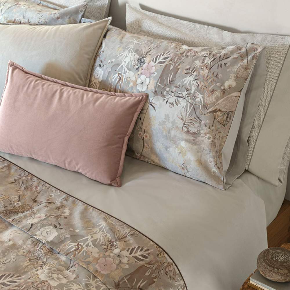 Completo lenzuola matrimoniale Fazzini Giardini d'Oriente, in pregiato percalle e raso di puro cotone. La collezione Giardini d'Oriente presenta una romantica fantasia floreale che ricorda i tessuti pregiati di fine Ottocento. Sul raso di cotone prendono vita rami in fiore e affascinanti uccelli dalle meravigliose piume. Colore grigio. La fantasia è presente sulla faccia superiore delle federe e sulla balza del lenzuolo di sopra, in raso di cotone. Il resto del completo è in percalle di cotone tinta unita.