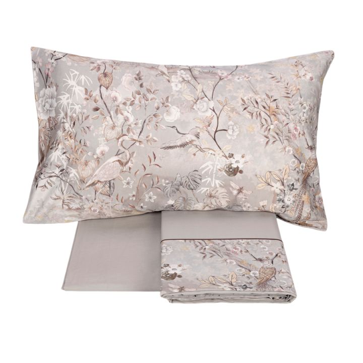 Completo lenzuola matrimoniale Fazzini Giardini d'Oriente, in pregiato percalle e raso di puro cotone. La collezione Giardini d'Oriente presenta una romantica fantasia floreale che ricorda i tessuti pregiati di fine Ottocento. Sul raso di cotone prendono vita rami in fiore e affascinanti uccelli dalle meravigliose piume. Colore grigio. La fantasia è presente sulla faccia superiore delle federe e sulla balza del lenzuolo di sopra, in raso di cotone. Il resto del completo è in percalle di cotone tinta unita.