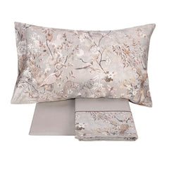 Completo lenzuola matrimoniale Fazzini Giardini d'Oriente, in pregiato percalle e raso di puro cotone. La collezione Giardini d'Oriente presenta una romantica fantasia floreale che ricorda i tessuti pregiati di fine Ottocento. Sul raso di cotone prendono vita rami in fiore e affascinanti uccelli dalle meravigliose piume. Colore grigio. La fantasia è presente sulla faccia superiore delle federe e sulla balza del lenzuolo di sopra, in raso di cotone. Il resto del completo è in percalle di cotone tinta unita.