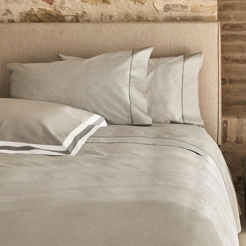 Completo lenzuola matrimoniale Fazzini Sashiko, in pregiato raso di puro cotone. Il completo lenzuola Sashiko presenta una moderna fantasia a puntini, con una doppia sovrastampa che dona tridimensionalità e movimento alla microfantasia. Variante di colore grigio. Le federe e il lenzuolo di sopra, impreziositi da balza tinta unita e codina inserita, sono in raso di puro cotone fantasia. Il resto del completo è in raso di puro cotone tinta unita.