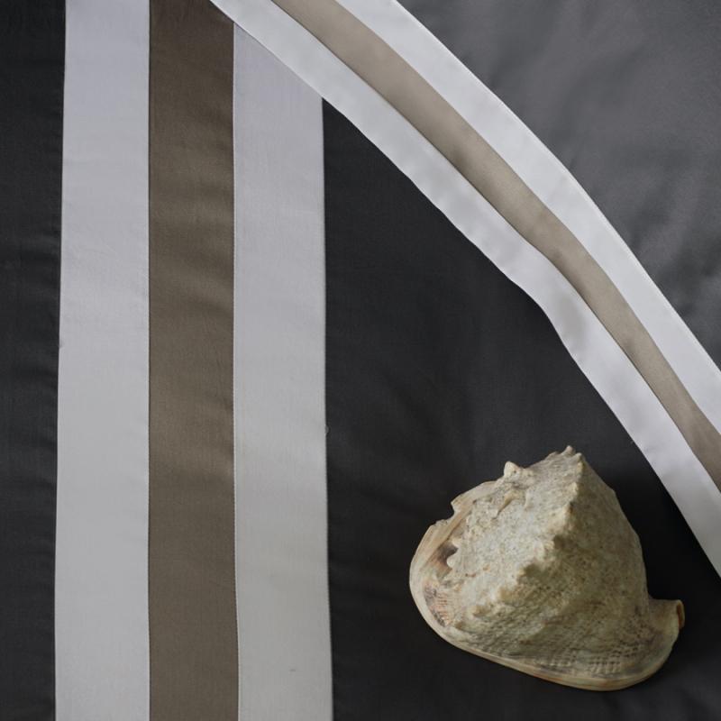 Completo lenzuola sentieri Fazzini matrimoniale grigio-sasso. lenzuolo tinta unita antracite con balza a contrasto.