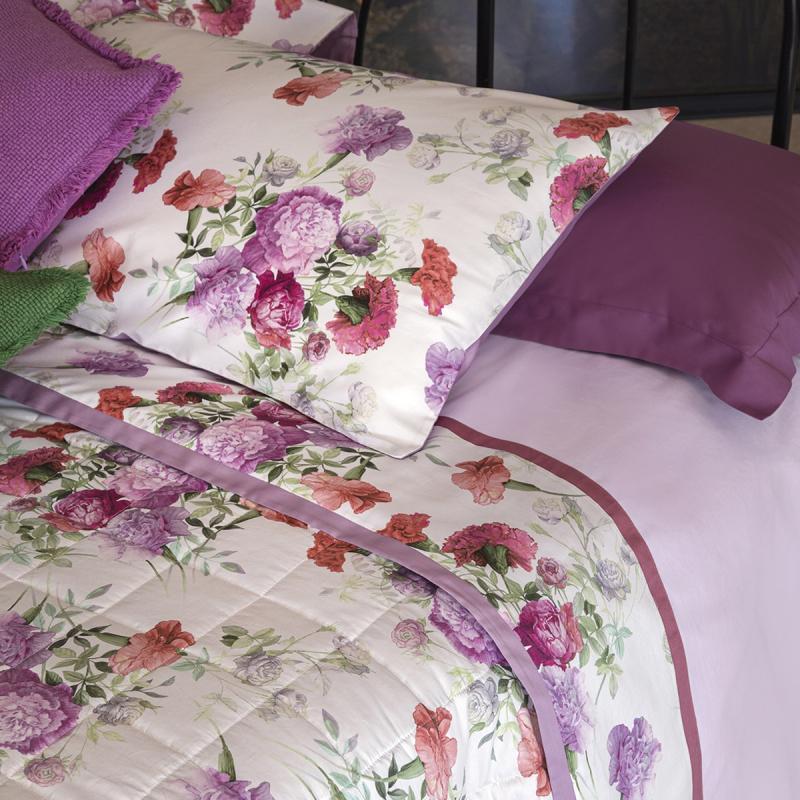 Completo lenzuola matrimoniale Fazzini Summer, in percalle e raso di puro cotone. La fantasia Summer è ispirata dalla bellezza del garofano. Il disegno romantico e vivido dei fiori decora le federe e la balza superiore del lenzuolo di sopra, entrambe in raso di cotone. Colore rosa glicine. La fantasia è presente sulla faccia superiore delle federe e sulla balza del lenzuolo di sopra, entrambe in raso di cotone. Il resto del completo è in percalle tinta unita rosa.