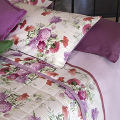 Completo lenzuola matrimoniale Fazzini Summer, in percalle e raso di puro cotone. La fantasia Summer è ispirata dalla bellezza del garofano. Il disegno romantico e vivido dei fiori decora le federe e la balza superiore del lenzuolo di sopra, entrambe in raso di cotone. Colore rosa glicine. La fantasia è presente sulla faccia superiore delle federe e sulla balza del lenzuolo di sopra, entrambe in raso di cotone. Il resto del completo è in percalle tinta unita rosa.