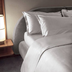 Completo lenzuola matrimoniale Fazzini Trecento, in raso di puro cotone tinta unita. Varianti di colore bianco seta. Le federe sono a 4 volani. Il raso di cotone da 300 fili per pollice quadrato dona freschezza, comfort e morbidezza al completo lenzuola