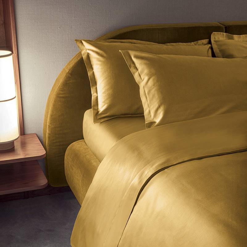 Completo lenzuola matrimoniale Fazzini Trecento, in raso di puro cotone tinta unita. Varianti di colore: ocra oro giallo.. Le federe sono a 4 volani. Il raso di cotone da 300 fili per pollice quadrato dona freschezza, comfort e morbidezza al completo lenzuola