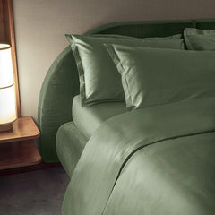 Completo lenzuola matrimoniale Fazzini Trecento, in raso di puro cotone tinta unita. Variante di colore verde. Le federe sono a 4 volani. Il raso di cotone da 300 fili per pollice quadrato dona freschezza, comfort e morbidezza al completo lenzuola