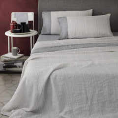 Completo lenzuola matrimoniale Marea di NK Camillatex, in puro lino. L'attenta scelta dei colori dona al completo un sapore moderno e ricercato. Colore bianco e nero. Il lenzuolo superiore presenta una fantasia rigata e un bordo tinto in filo di colore più scuro. Quest'ultima colorazione la si ritrova anche sul lenzuolo con angoli. Le federe a sacchetto ripropongono lo stesso abbinamento del lenzuolo.