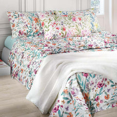 Lenzuolo Copriletto matrimoniale Amelie, in percalle di cotone. Realizzato in Italia da Somma. Il completo lenzuola Amelie è caratterizzato da una vivace fantasia floreale in tre varianti di colore: la prima con fiori arancione e foglie verde salvia, la seconda con fiori rosso/corallo e malva e foglie verdi, la terza con fiori gialli e foglie bluette. La stampa è presente sulle federe e sul lenzuolo superiore, compresa la balza. Il lenzuolo con angoli è in falso unito color verde acqua, rosa o giallo.