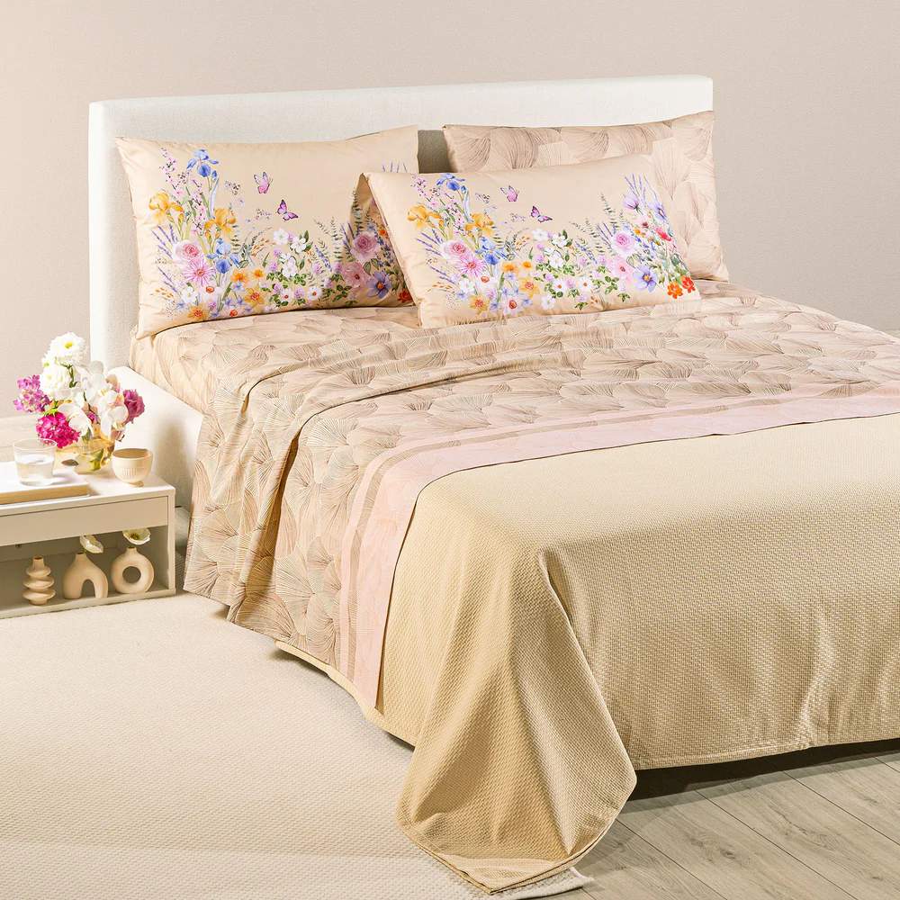 completo lenzuola caleffi yasmine. federe con fantasia a fiorellini arancio, rosa e blu. lenzuolo con foglie di ginkgo. variante naturale beige.