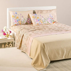 completo lenzuola caleffi yasmine. federe con fantasia a fiorellini arancio, rosa e blu. lenzuolo con foglie di ginkgo. variante naturale beige.