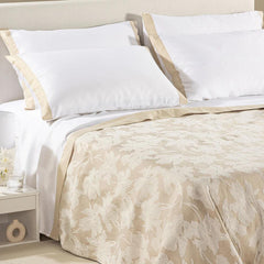 Copriletto estivo Cala Luna fantasia jacquard con foglie chiare su fondo naturale beige.