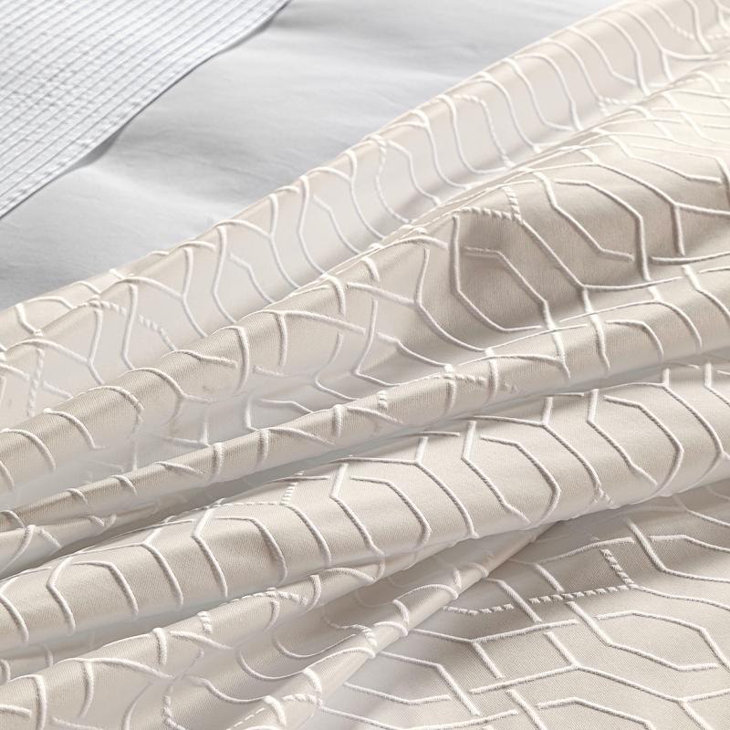 Copriletto matrimoniale Villa Necchi, della linea Fazzini Atelier, in prezioso raso jacquard. La coperta estiva Villa Necchi presenta in un gioco tono su tono un bel motivo tridimensionale d'ispirazione dèco, con una mano morbida e voluminosa. Variante di colore champagne/avorio. Il copriletto Villa Necchi è trapuntato a capo e rifinito a mano con due angoli sagomati che lo adattano perfettamente agli angoli del letto.