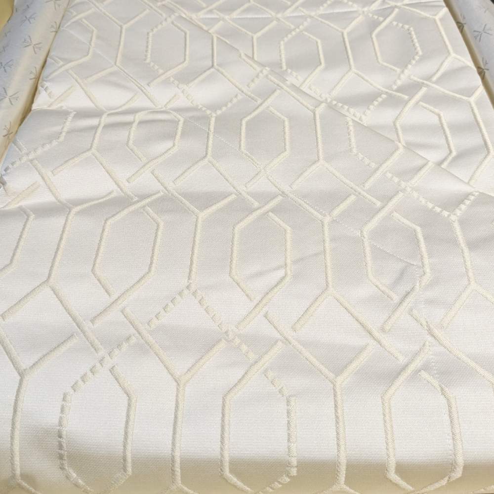 Copriletto matrimoniale Villa Necchi, della linea Fazzini Atelier, in prezioso raso jacquard. La coperta estiva Villa Necchi presenta in un gioco tono su tono un bel motivo tridimensionale d'ispirazione dèco, con una mano morbida e voluminosa. Variante di colore champagne/avorio. Il copriletto Villa Necchi è trapuntato a capo e rifinito a mano con due angoli sagomati che lo adattano perfettamente agli angoli del letto.