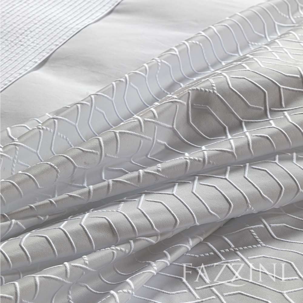 Copriletto matrimoniale Villa Necchi, della linea Fazzini Atelier, in prezioso raso jacquard. La coperta estiva Villa Necchi presenta in un gioco tono su tono un bel motivo tridimensionale d'ispirazione dèco, con una mano morbida e voluminosa. Variante di colore champagne/avorio. Il copriletto Villa Necchi è trapuntato a capo e rifinito a mano con due angoli sagomati che lo adattano perfettamente agli angoli del letto.