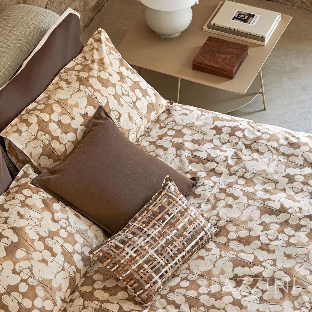 Copripiumino matrimoniale Fazzini Lunaria, in percalle di puro cotone. Il copripiumino Lunaria presenta una fantasia floreale dallo stile moderno, con fiori chiari su fondo tortora/cammello. Il set include un sacco copripiumino e due federe