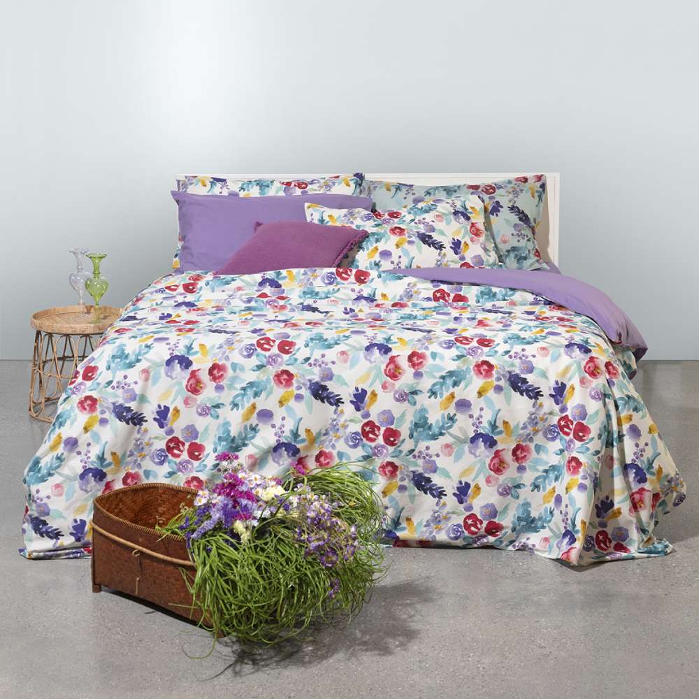 Copripiumino Fazzini petali matrimoniale. Fantasia con fiori viola, ottanio, rosso e giallo in stile acquerello su fondo bianco