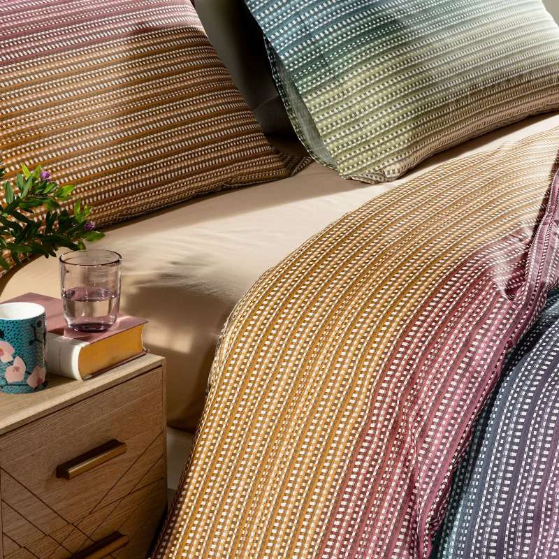 Completo copripiumino Iride di Caleffi, in puro cotone anallergico e traspirante. Disponibile nella misura per letto singolo, piazza e mezza e matrimoniale.
Fantasia moderna multicolore. Dettaglio fantasia.