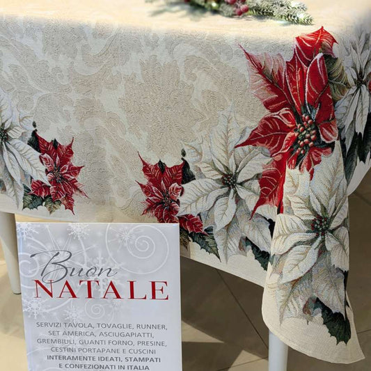Copritavolo Natalizio Favola di Emily Home, in tessuto Gobelin. Misura rettangolare x12 (140x260 cm) Il copritavolo Favola presenta una delicata fantasia floreale natalizia su fondo platino. Sugli angoli risaltano stelle di Natale bianche e rosse