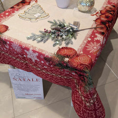 Copritavolo Natalizio Special di Emily Home, in tessuto Gobelin. Misura rettangolare x12 (140x260 cm) Il copritavolo Special presenta un'ampia cornice rossa, attraversata da un pattern decorativo a contrasto. Sui bordi del piano tavola color crema, sono presenti sfere natalizie rosse.