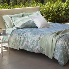 Lenzuolo Copriletto matrimoniale Fazzini Kimono in percalle di puro cotone. Il lenzuolo di sopra e le federe con quattro volanini sono in percalle di puro cotone stampato. Anche il risvolto del lenzuolo è stampato. Fantasia floreale con fiorellini bianchi su fondo verde acqua