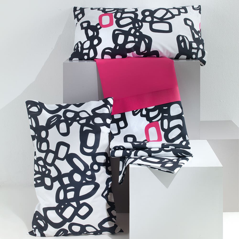 Lenzuolo Copriletto matrimoniale Party in puro cotone. Realizzato in Italia da Gabel.Il completo lenzuola Party presenta una fantasia moderna in cui elementi geometrici fucsia spiccano sul fondo geometrico bianco e nero. Variante fucsia rosa. La stampa è presente sulle federe e sul lenzuolo superiore, mentre la balza è in tinta unita. Il lenzuolo con angoli presenta una fantasia con puntini neri su fondo bianco