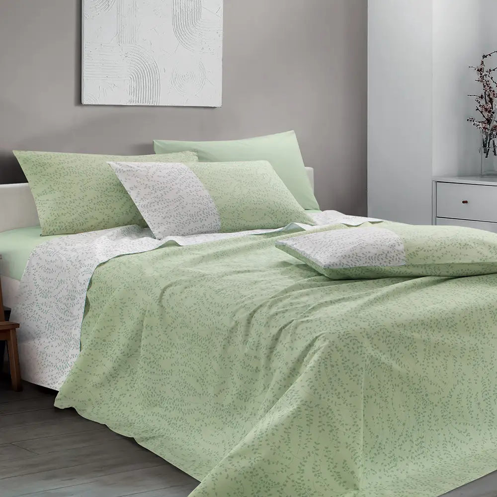 Lenzuolo copriletto Gabel in cotone. Fantasia fondo verde con foglioline più scure. Risvolto del lenzuolo bianco con foglioline.