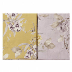 Lenzuolo copriletto matrimoniale Atelier 31, di Tessitura Randi, in percalle di puro cotone. Romantica fantasia con fiori chiari su fondo glicine. La fantasia con fondo glicine è presente sul lenzuolo di sopra e sulle federe. Il risvolto del lenzuolo di sopra è stampato, essendo un lenzuolo copriletto. Il lenzuolo con angoli presenta la stessa fantasia ma con fondo giallo ocra.