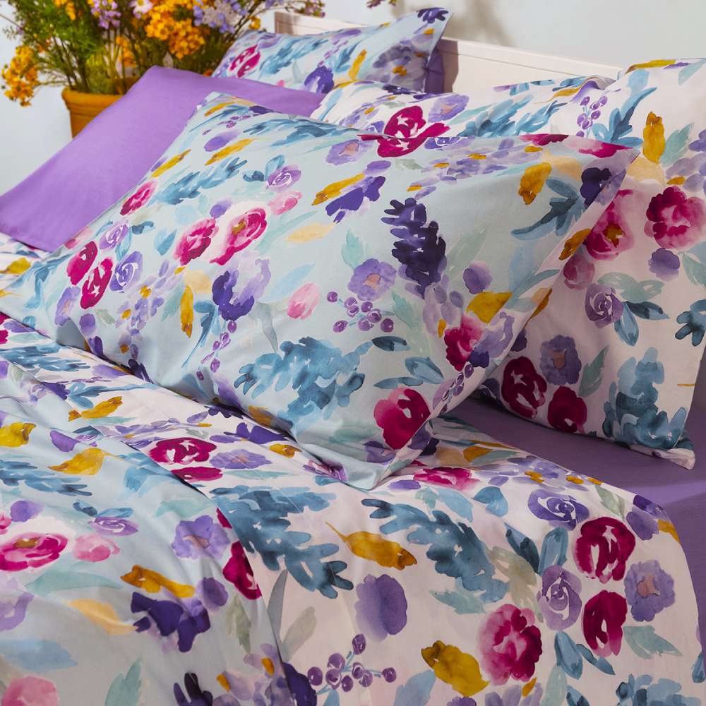 Lenzuolo copriletto Fazzini petali matrimoniale. Fantasia fiori rosi, gialle e viola ad acquerello su fondo azzurro e bianco.