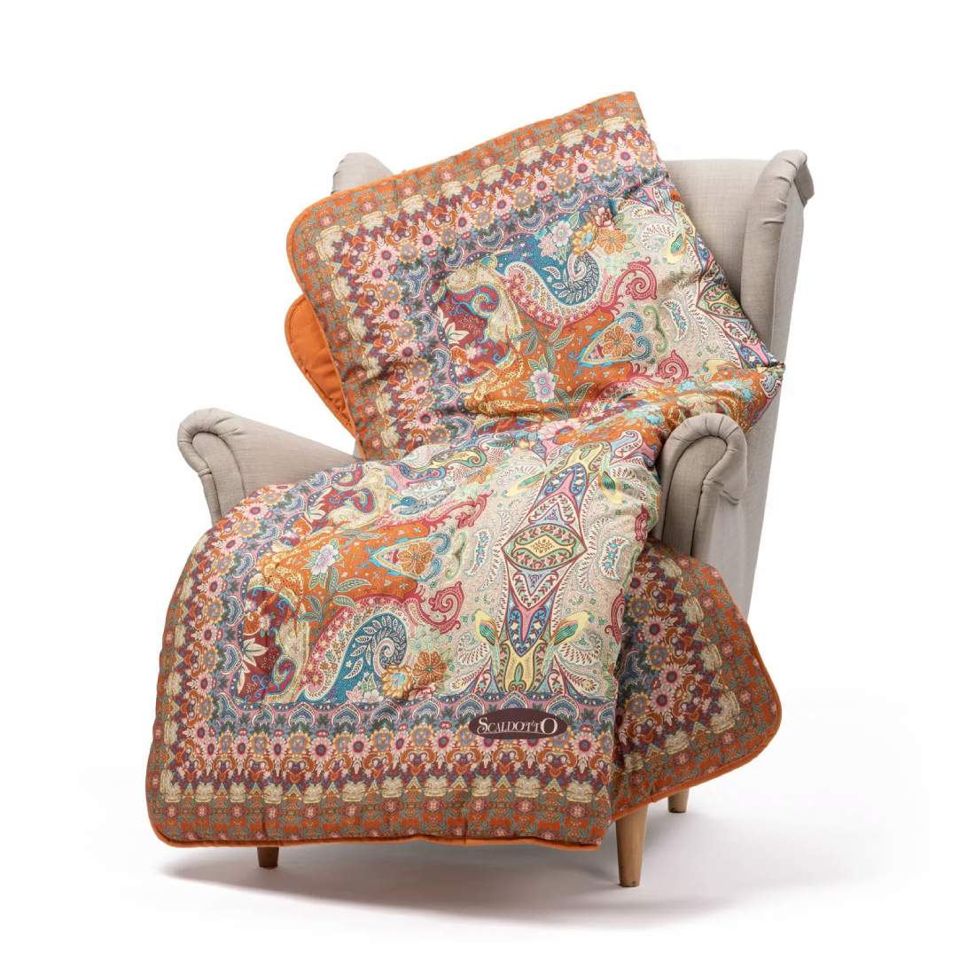 Scaldotto Alhambra di Caleffi, in cotone caldo con stampa digitale. Vivace fantasia multicolore, variante ambra. Lo Scaldotto è un morbido plaid con esterno in cotone smerigliato effetto cashmere, che offre una sensazione di morbidezza e comfort sulla pelle.