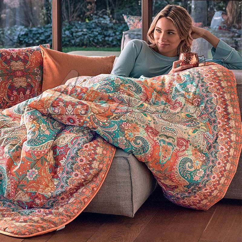 Scaldotto Alhambra di Caleffi, in cotone caldo con stampa digitale. Vivace fantasia multicolore, variante ambra. Lo Scaldotto è un morbido plaid con esterno in cotone smerigliato effetto cashmere, che offre una sensazione di morbidezza e comfort sulla pelle.