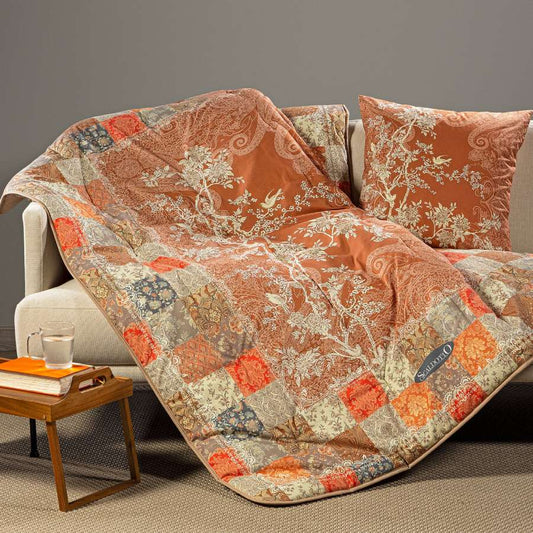 Scaldotto Caleffi Berry. Fantasia con piante e uccelli su fondo ambra/arancio e bordo patchwork. Plaid in cotone caldo.