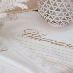 Telo mare Blumarine Isola, in spugna di puro cotone. Telo mare elegante e raffinato, con logo Blumarine ricamato e righe dorate tinte in filo su fondo avorio. Fronte liscio e retro in micro spugna di cotone. Spugna di cotone idrofilo da 300 g/mq. Misura: 100x180 cm.