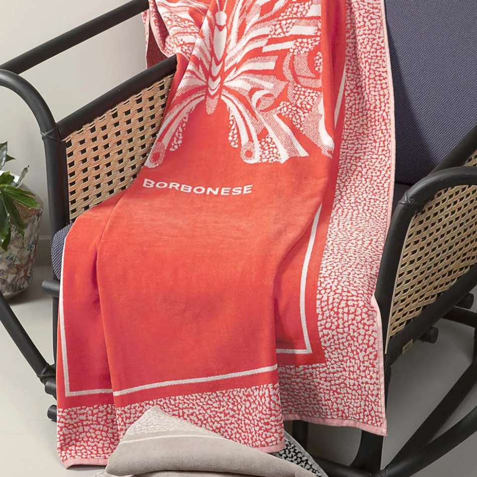 Telo mare Borbonese Butterfly, in spugna di puro cotone.Il telo mare Butterfly è caratterizzato da una stampa centrale raffigurante una farfalla, un dettaglio distintivo che unisce eleganza e originalità. Il bordo presenta la tipica stampa Borbonese a occhio di pernice. Colore corallo arancione.