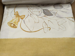Tovaglia natalizia Mirage di Tessitura Randi. Stampa digitale su panama di puro cotone. Fantasia su fondo avorio con delicata fantasia con foglie, nastrini ed elementi tipici del Natale nei colori oro e grigio. Disponibile nella misura rettangolare x12 (150x270 cm) o x18 (150x360 cm). dettaglio fantasia bordo ocra