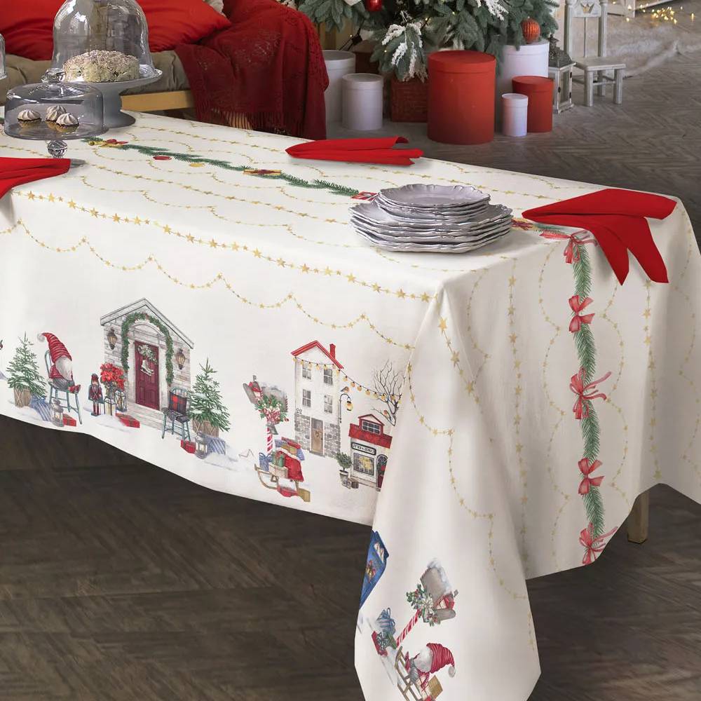 Tovaglia natalizia Village di Tessitura Randi. Stampa digitale su puro cotone. Fantasia su fondo avorio con elementi tipici del periodo natalizio: casette illuminate, alberi di Natale e slitte con regali adornano i lati della tovaglia. La parte centrale è abbellita da ghirlande e catenine con stelle dorate. Misura rettangolare x12: 150x270 cm.