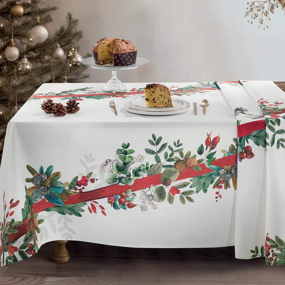 Tovaglia natalizia Ribbon di Gabel. Tovaglia rettangolare, in panama di puro cotone con fantasia piazzata. La tovaglia Ribbon presenta una raffinata fantasia natalizia. Sul fondo bianco risalta una fascia di foglie e ghirlande abbinate a un elegante nastro rosso