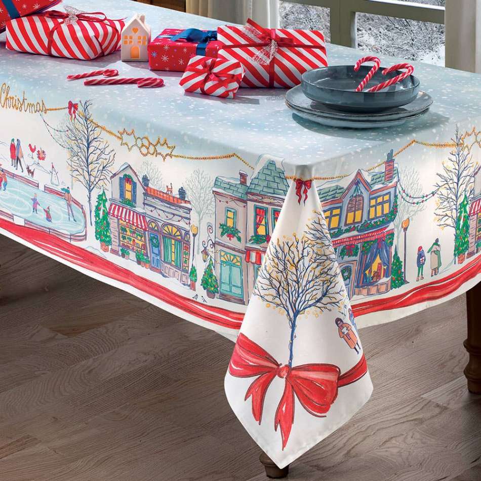 Tovaglia natalizia Snowland di Gabel. Tovaglia rettangolare, in panama di puro cotone con fantasia piazzata. La tovaglia Snowland presenta una vivace fantasia natalizia, con piste da pattinaggio sul ghiaccio e case addobbate per le feste. Il tutto incorniciato da uno sgargiante fiocco rosso e da una catenina dorata. Misure disponibili: Rettangolare x8 (150x220 cm), Rettangolare x12 (150x270 cm)