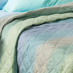 Trapuntino Caleffi Iride in morbida microfibra. Disponibile nella misura per letto singolo, piazza e mezza e matrimoniale. Trapunta primaverile dalla vivace fantasia geometrica con effetto degradè, colore laguna (verde,azzurro)