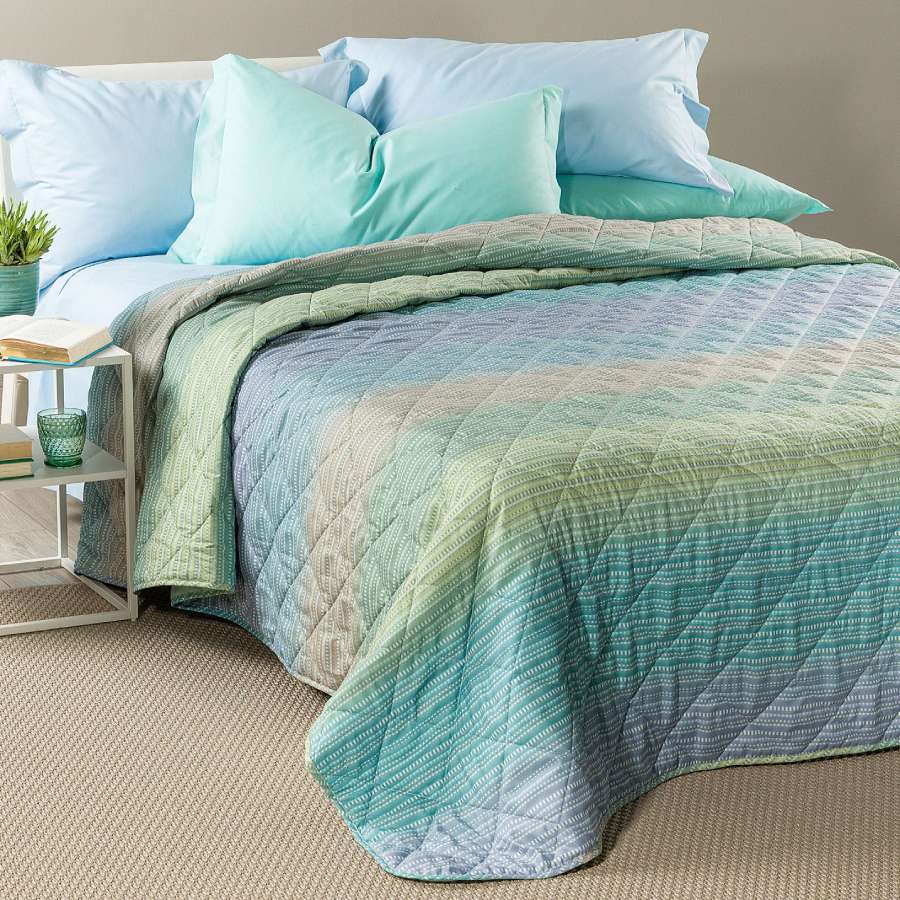 Trapuntino Caleffi Iride in morbida microfibra. Disponibile nella misura per letto singolo, piazza e mezza e matrimoniale. Trapunta primaverile dalla vivace fantasia geometrica con effetto degradè, colore laguna (verde,azzurro)